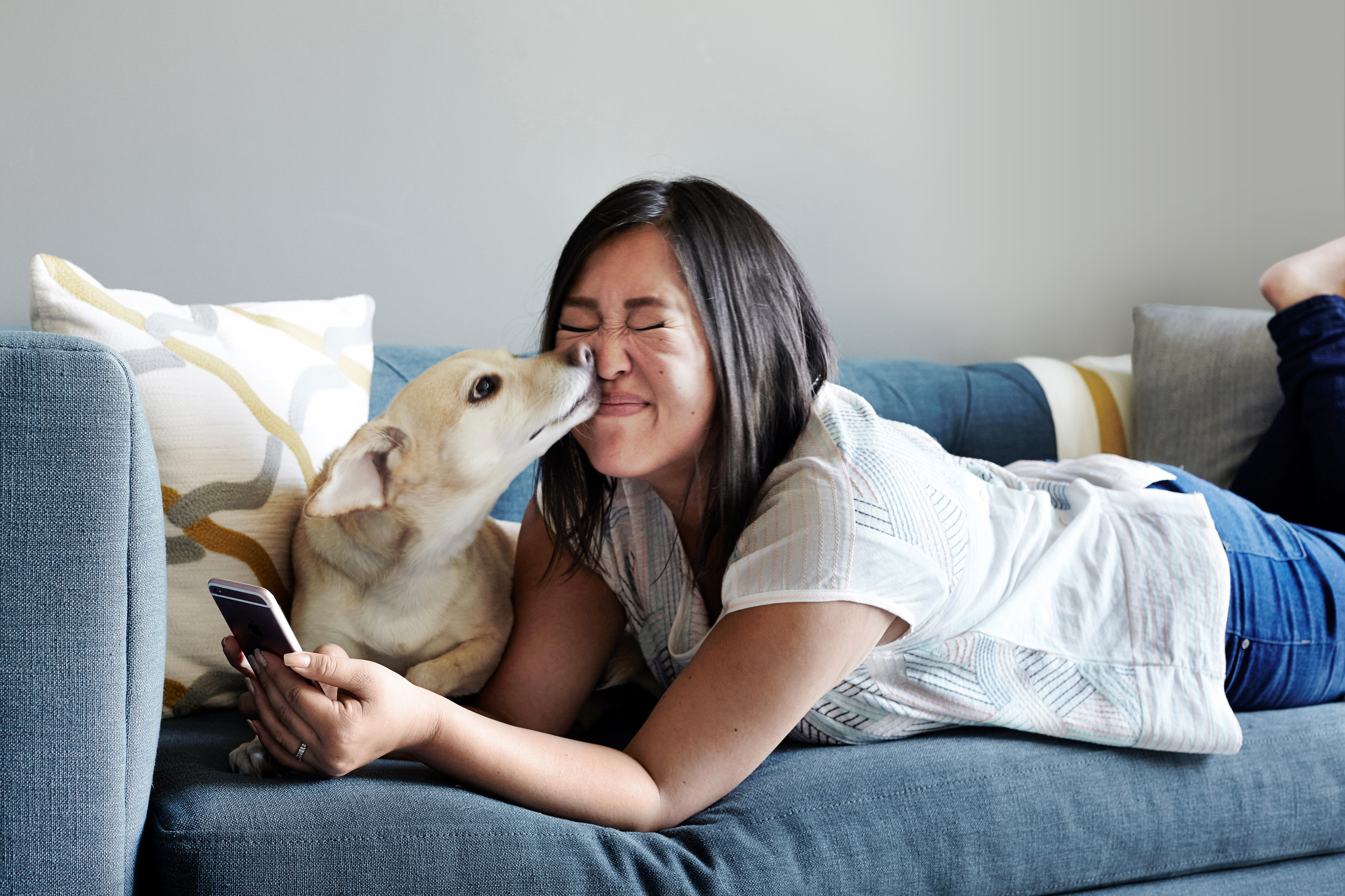 women on phone getting kissed by dog